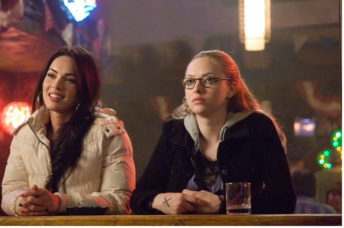 Megan Fox as Jennifer (left) and Amanda Seyfried as Anita (right) sit a bar.