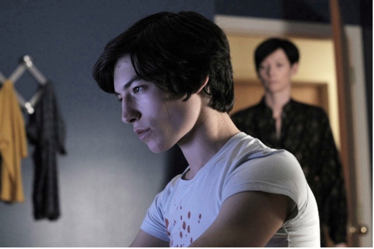 In the foreground, Ezra Miller is Kevin and Tilda Swinton is in the background as Eva. 