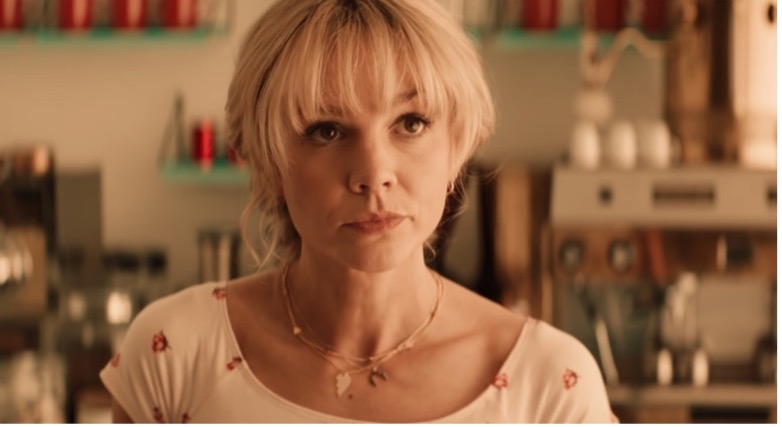 Close-up image of Cassie, played by Carey Mulligan as she stands in a coffee shop.